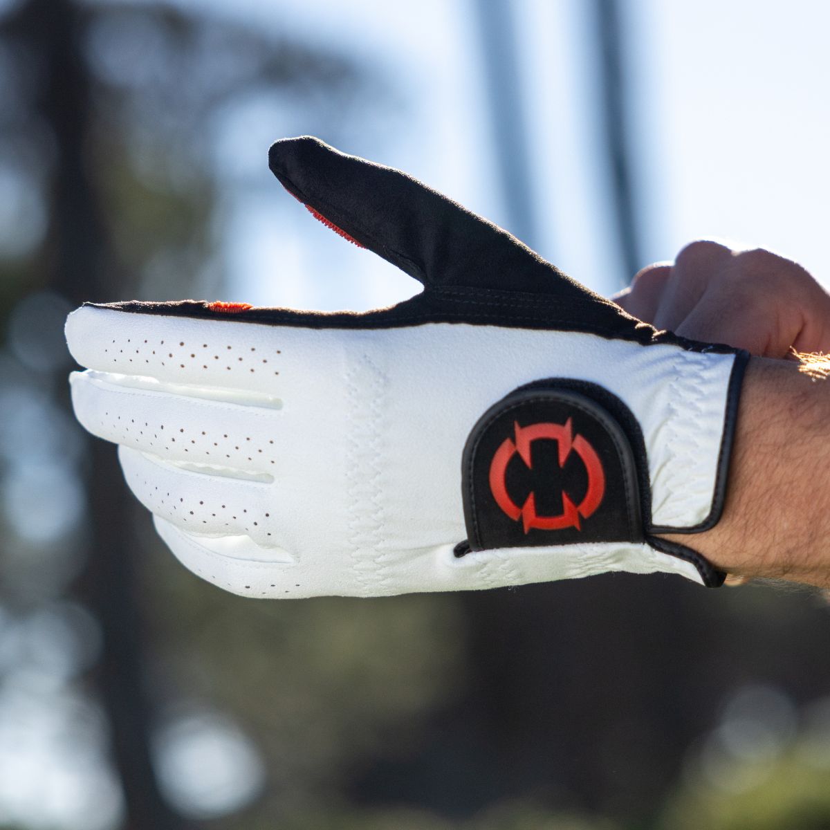 EXO Golf Glove withe red logo - golfer putting on the glove