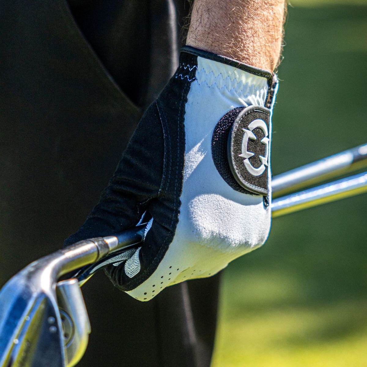 EXO golf Glove withe white logo - golfer holding two golf clubs