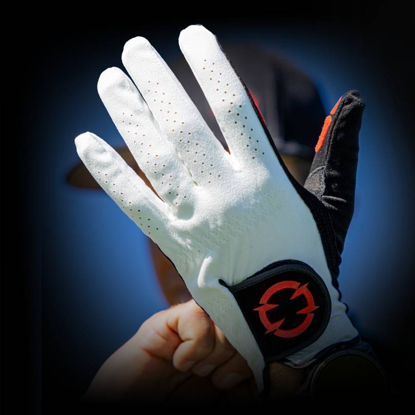 Golfer putting on the EXO golf glove with the back of hand showing and red EXO logo